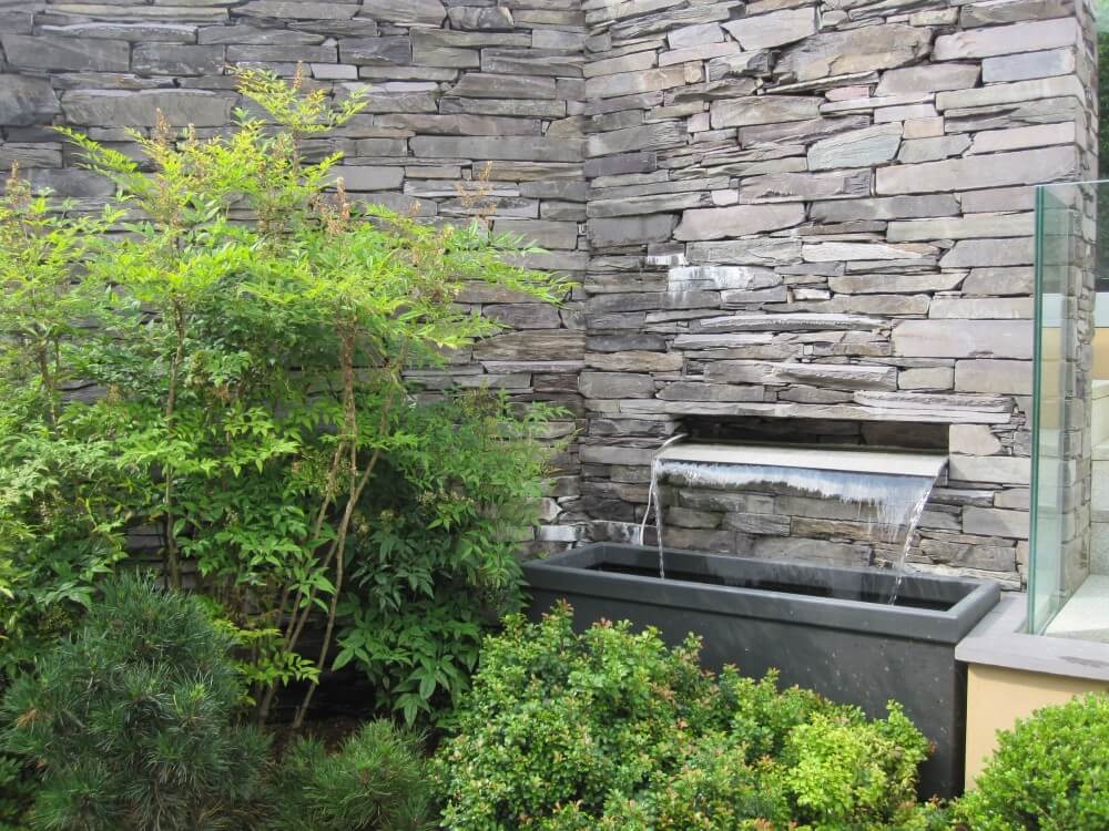 Stainless steel water rill in slate wall